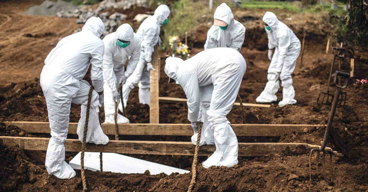 Các nhân viên nghĩa trang đang chôn cất thi thể bệnh nhân Covid-19 tại Indonesia. Ảnh: AFP.